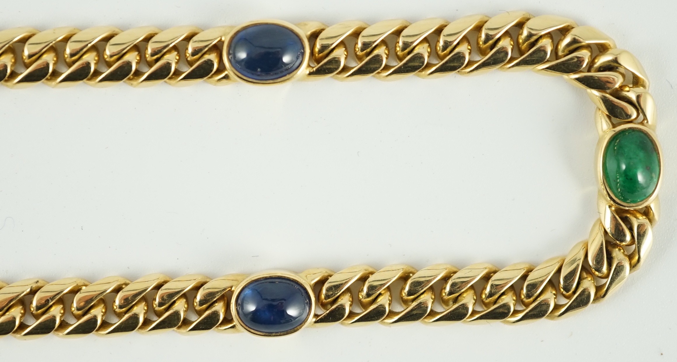 A modern 18ct gold, four stone cabochon sapphire and three stone cabochon emerald set curblink necklace